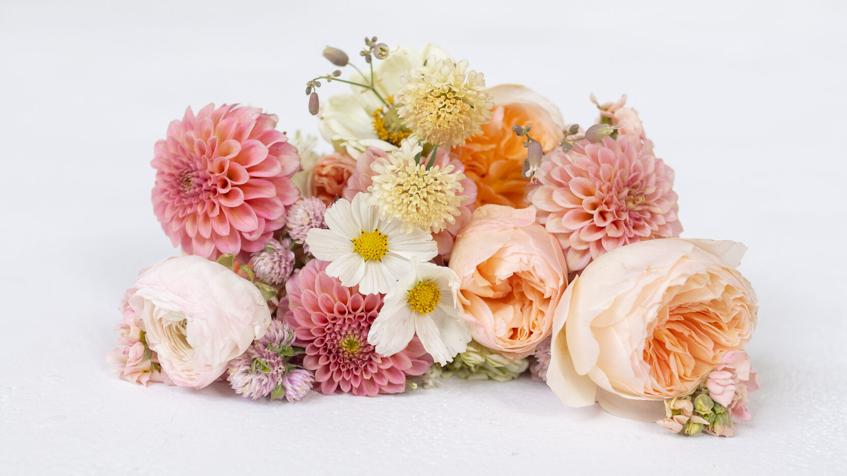 A colorful bouquet with pink, white, and peach-colored flowers.